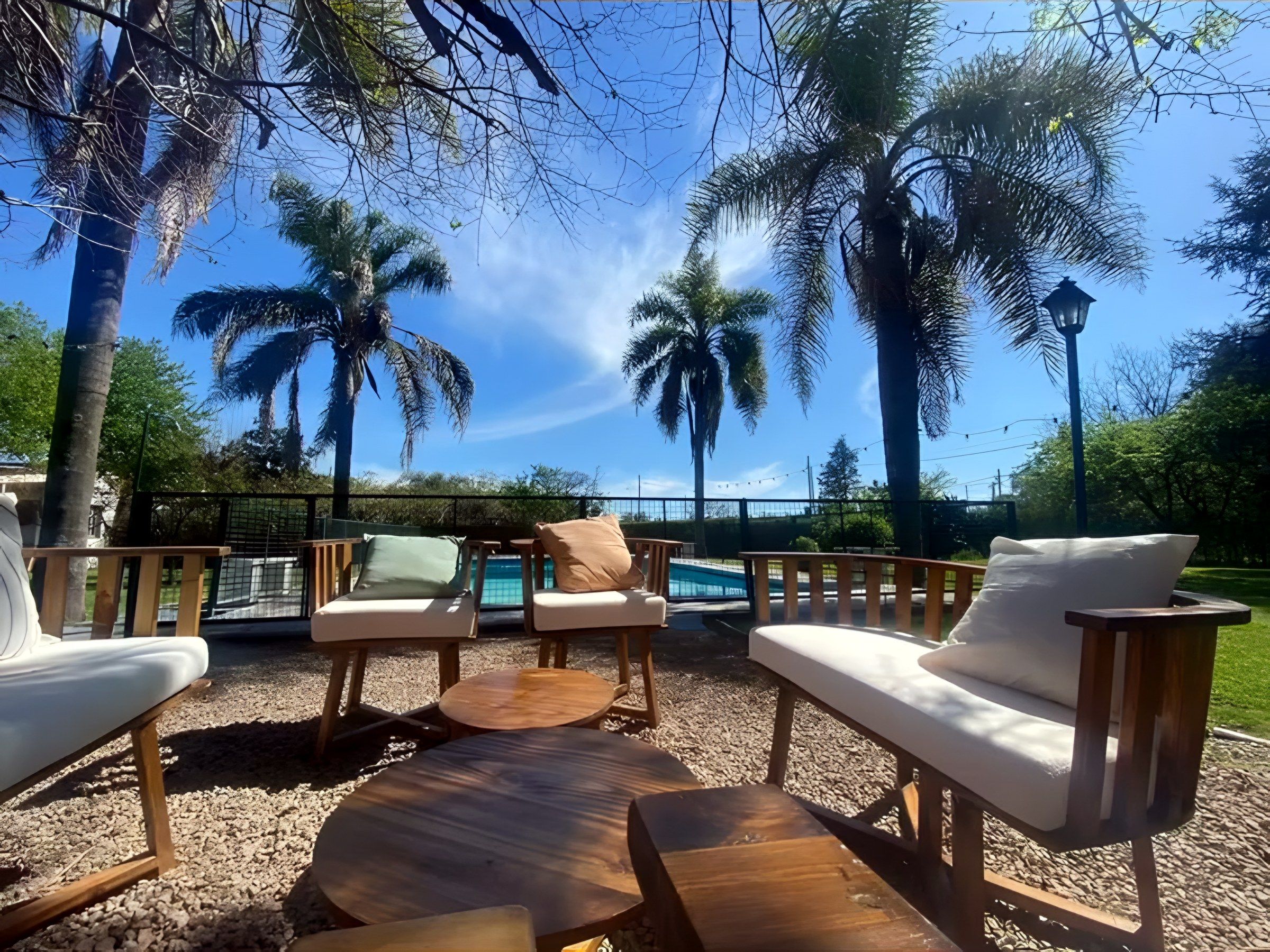 Deck con livings de madera junto a la pileta