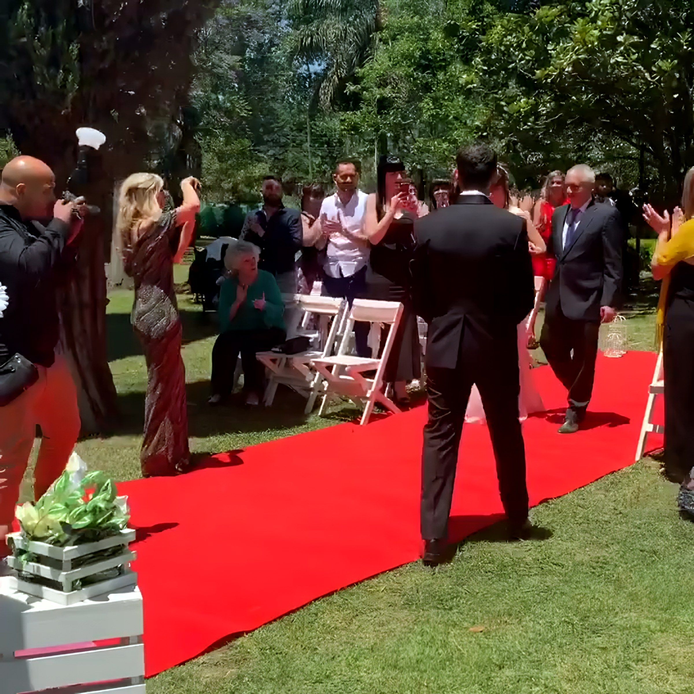 Pasillo de alfombra roja con invitados parados